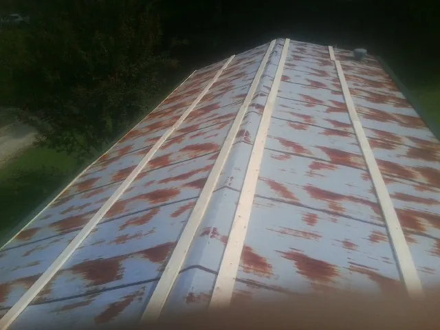 Rusted metal roof panels with new wood purlins before replacement — Storm Damage Roof Repair in Mangum by Roofing Brothers