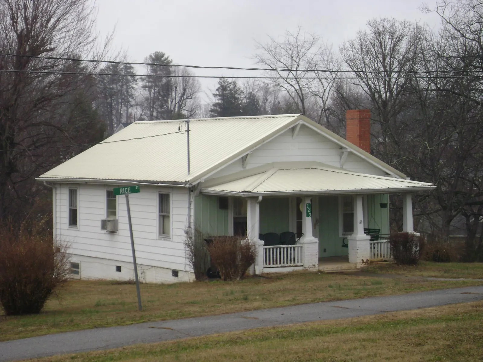 White metal roof on a craftsman bungalow at a street corner in Mangum