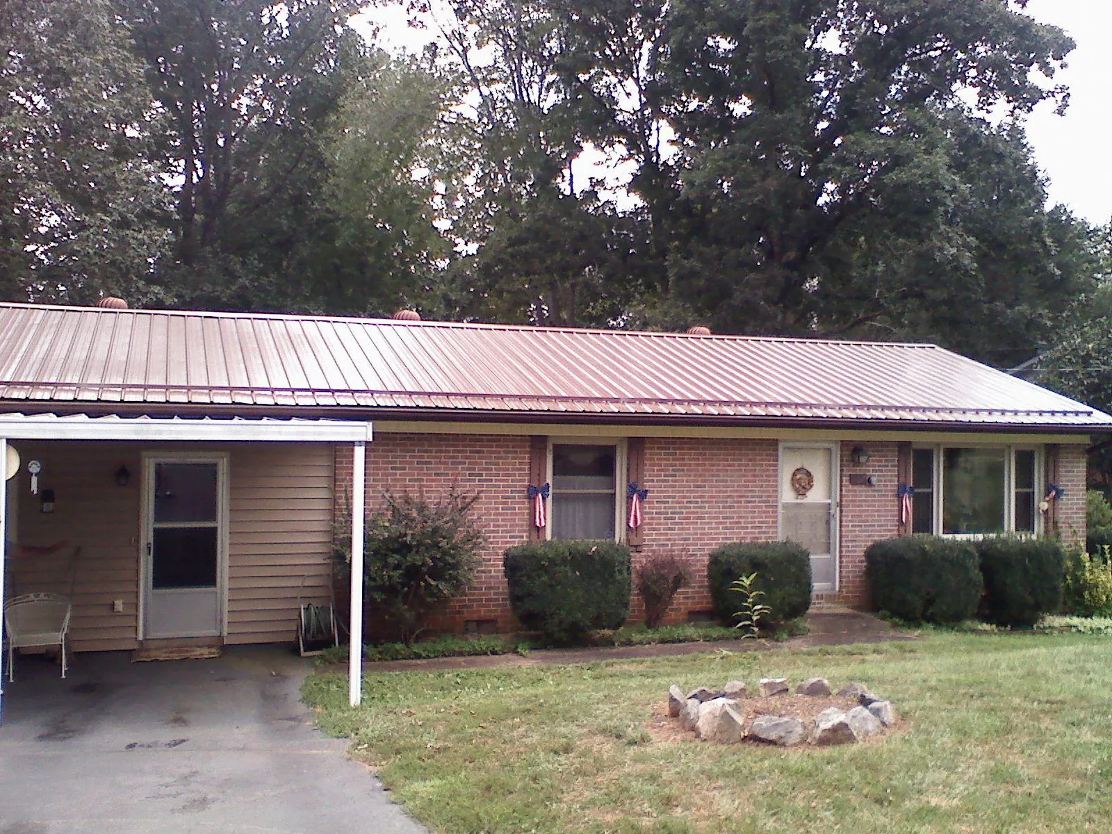 Bronze metal roof and carport on a brick ranch home — Roof Repair work by our crew in Mangum